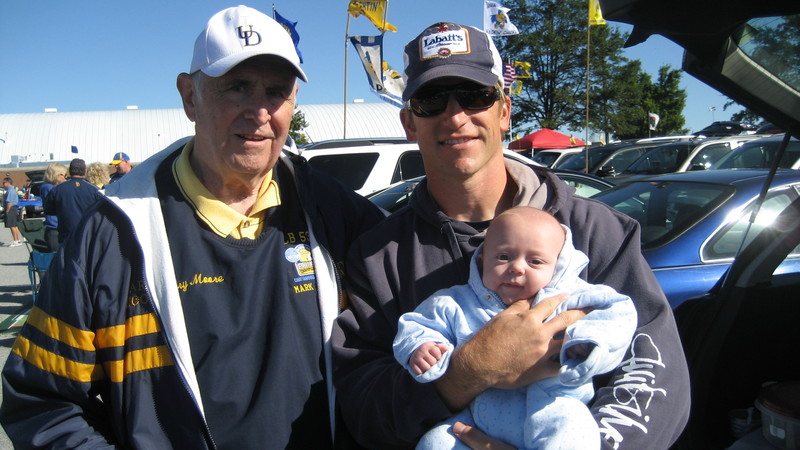 Harry Moore, left, stands with grandson Mark Moore and great-grandson Mason Moore outside the University of Delaware-Delaware State football game in 2009. BY SUBMITTED